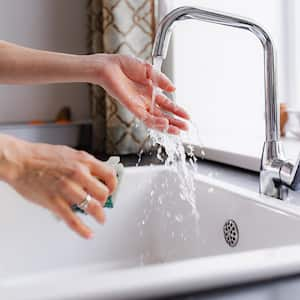 woman washing hands in kitchen sink